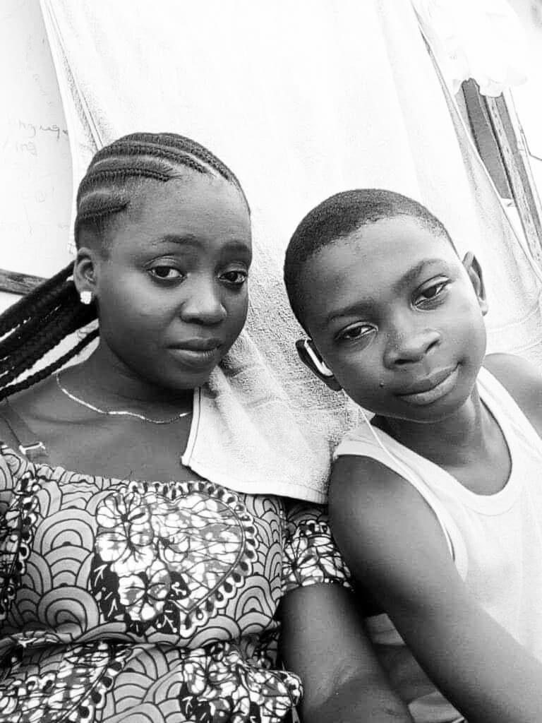 Black and white portrait of girl with braids and boy in a tank top.